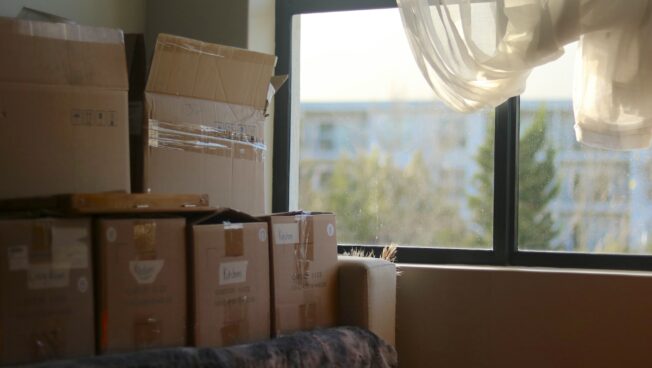 dorm room with boxes by a window