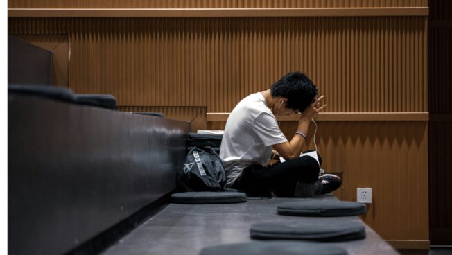 University student sitting lonely on campus